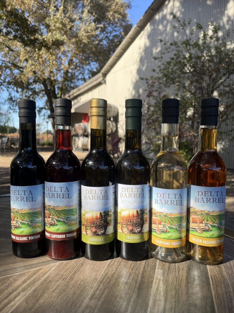 Six Delta Barrel bottles lined up outdoors