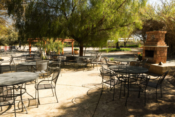 Shaded outdoor patio with metal tables.