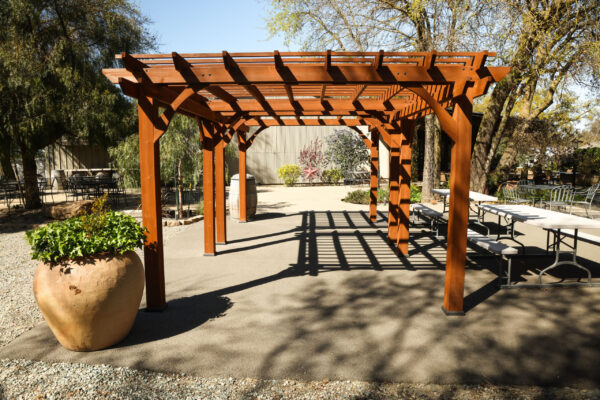Wooden pergola casting shadows over patio.