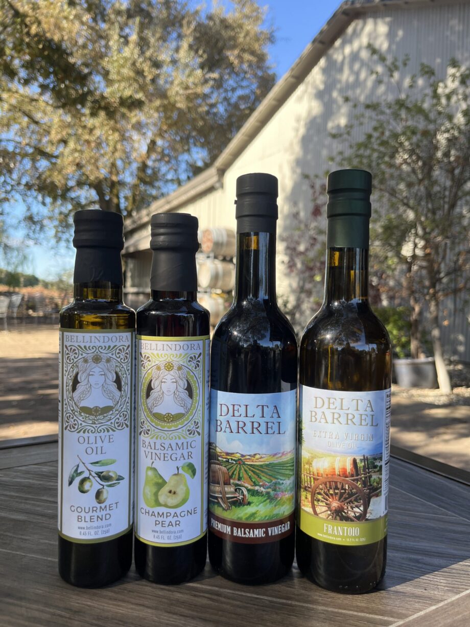Four olive oil and vinegar bottles outdoors